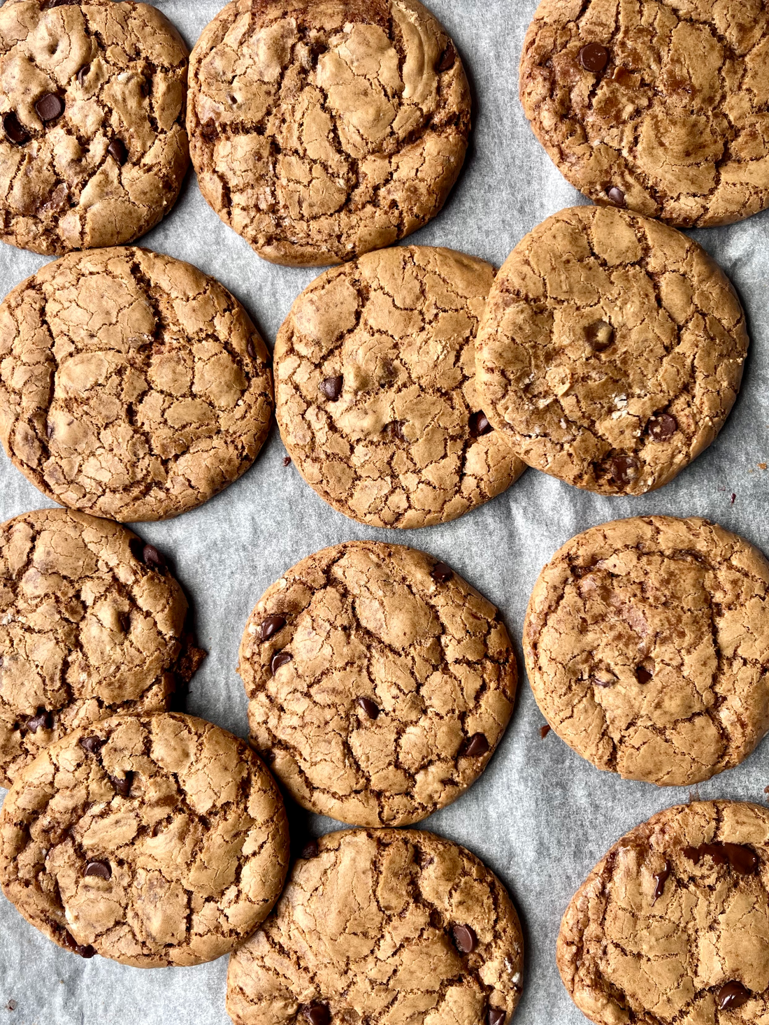 freshly baked chocolate chip and smoked sea salt cookies on parchment paper